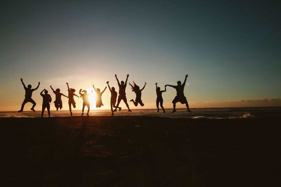 silhouette photography of group of people jumping during golden time — Souvenir hunting with live currency conversion in your pocket.