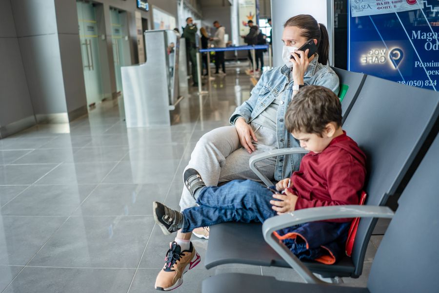 mother and son waiting at the airport — The rental desk handshake: confirmation email open, license photo ready.