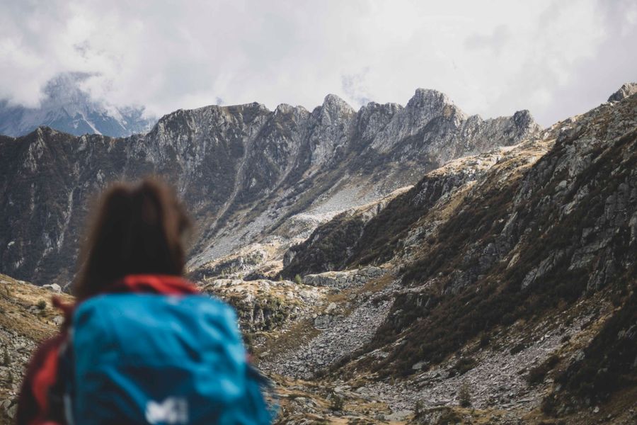 woman with a backpack in the mountains — Docs: La credencial de la conferencia: boleto QR escaneado, agenda sincronizada.