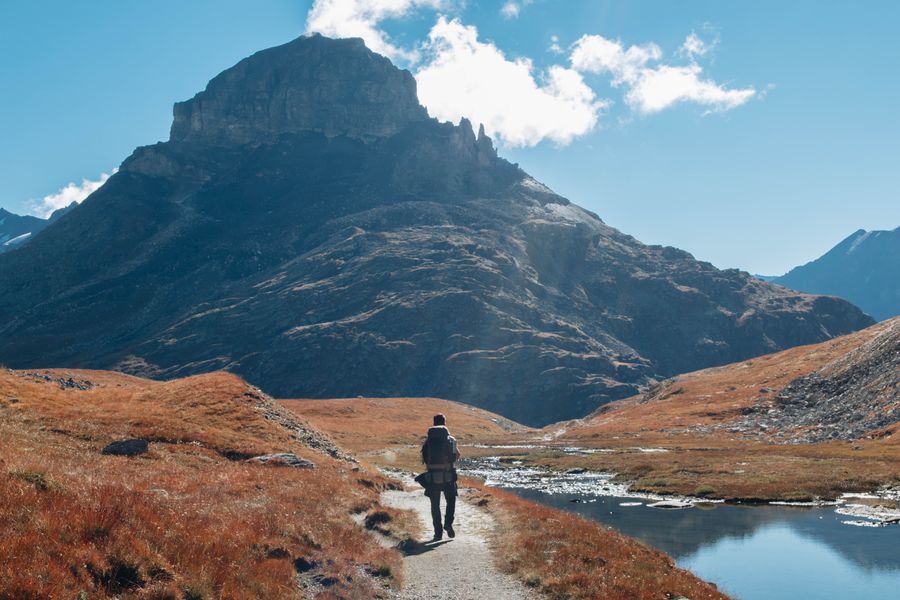 man walking at a river in mountains — Verifica la compatibilidad primero — la herramienta confirma tu modelo en segundos.