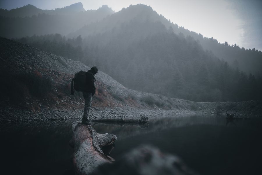 a man standing on wood log — ¿Lluvia en Equatorial Guinea? La conexión aguanta — el clima no limita los datos.