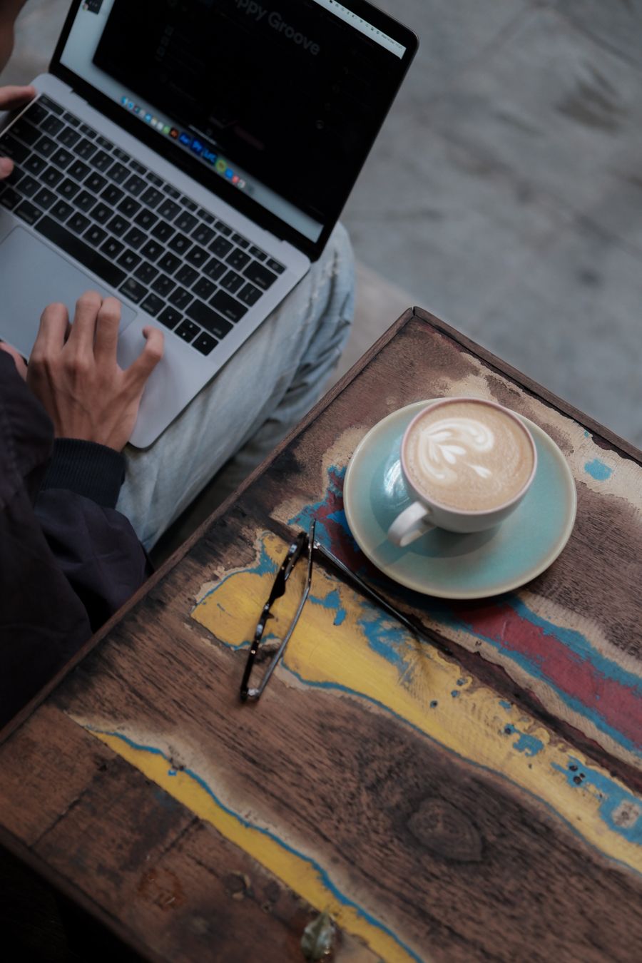 using a laptop and drinking coffee