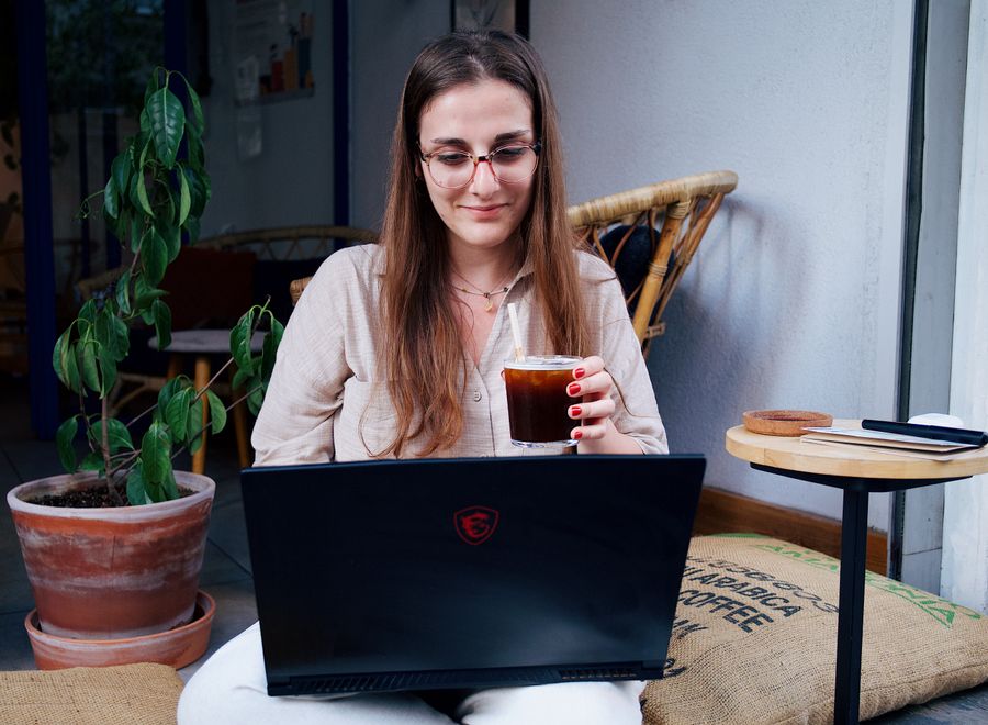 a woman sitting with a laptop — Los viajeros siguen en línea desde que aterrizan — sin colas de SIM, sin sustos de roaming.