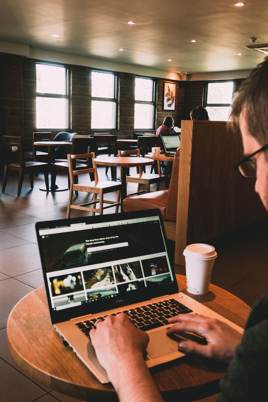 man using macbook on wooden table — El exprés al aeropuerto de Uruguay: boleto en la billetera antes de que aterrice el avión.