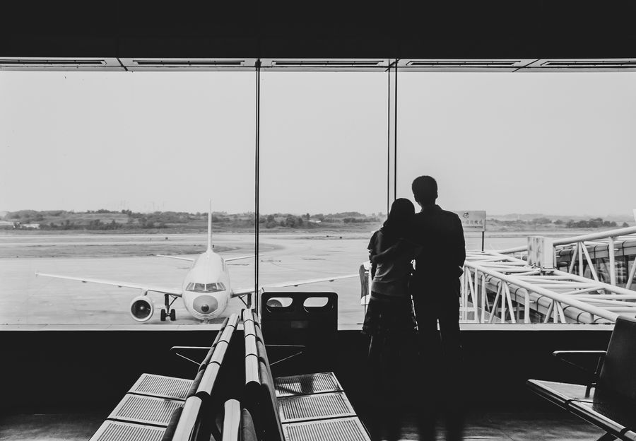 back view of couple embracing at airport — Oficinas-café en Uruguay: zona wifi estable, sin ruleta de wifi de hotel.