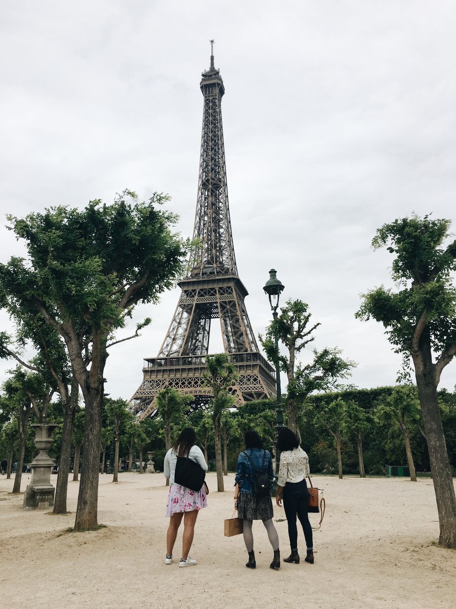 three women watching the eiffel tower — The group chat stays live across every border you cross.