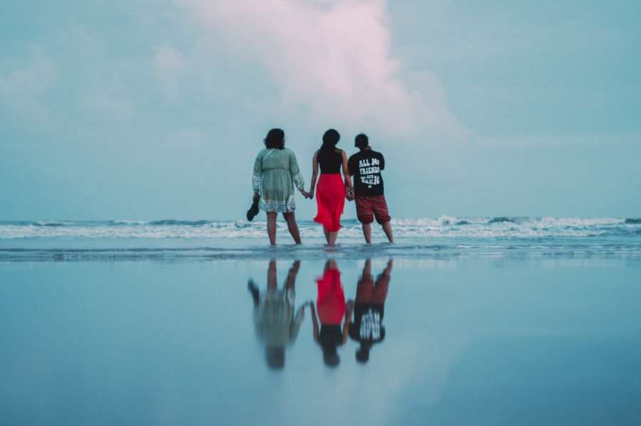 three people walking on the beach with the ocean in the background — The FAQ below eSIM Installation Guide answers the six questions everyone asks first.
