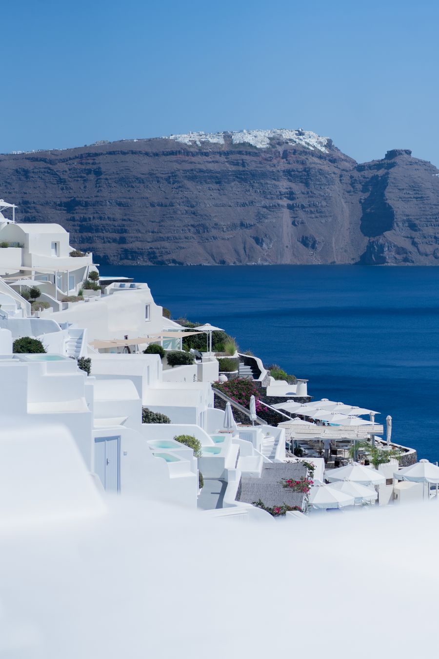 a white building with blue roof and water in the background — Changelog: Cada entrada enlaza los docs que afecta — changelog como mapa.