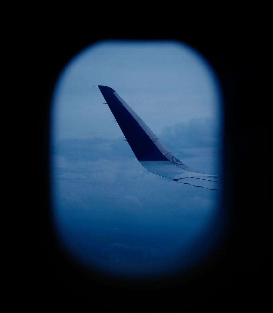 aerial view of airplane wing through window — La escala en Mexico: trabajar, streaming y mensajes, todo cubierto.