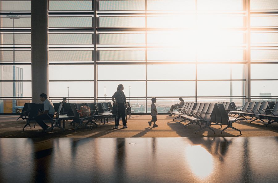 modern airport terminal with travelers at sunrise — Developers: Los webhooks avisan cuando los datos bajan, los planes expiran, las recargas llegan.
