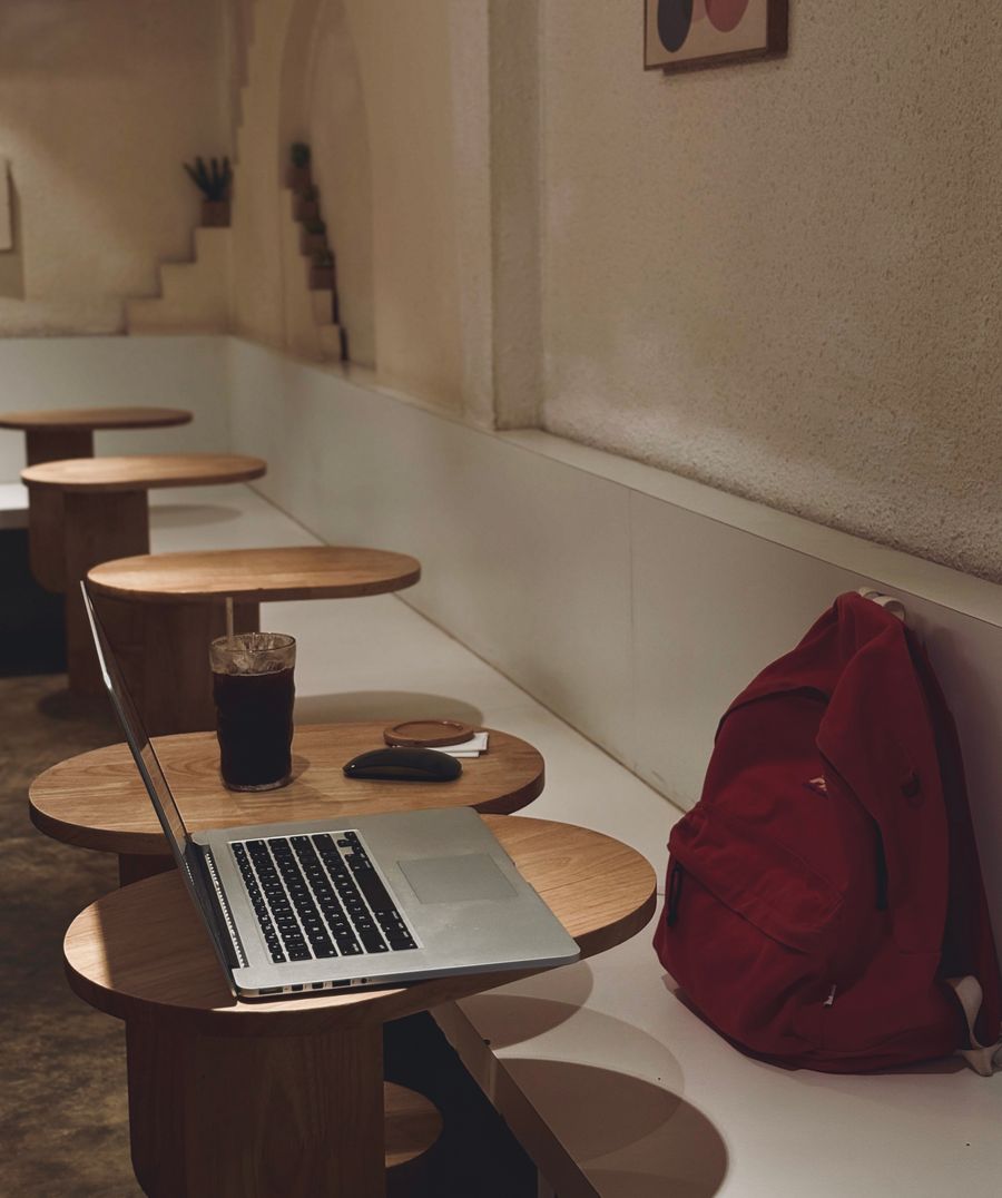cozy cafe workspace with laptop and drink — Best Network by City: tell it about the trip, get the answer in under a minute.