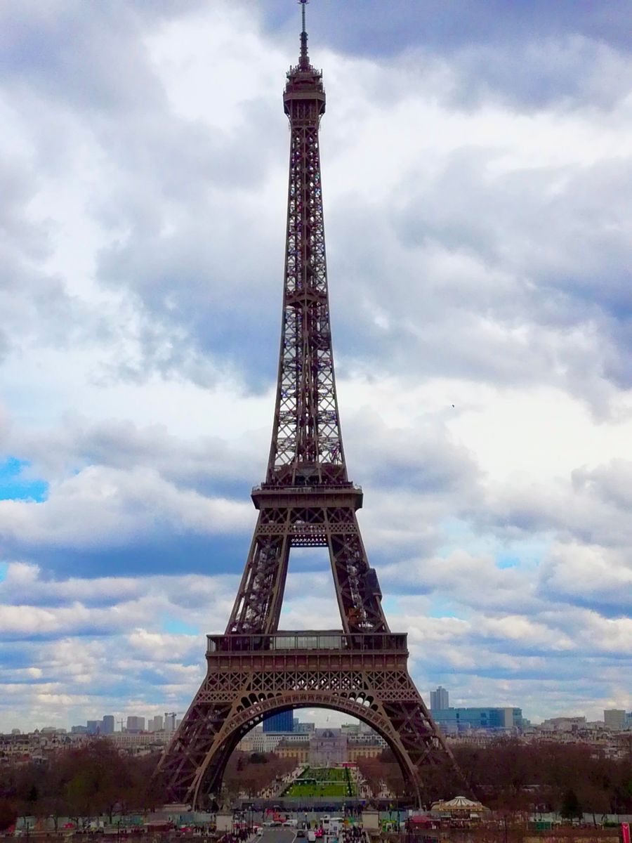eiffel tower in paris against cloudy sky — Support: Los viajeros siguen en línea desde que aterrizan — sin colas de SIM, sin sustos de roaming.