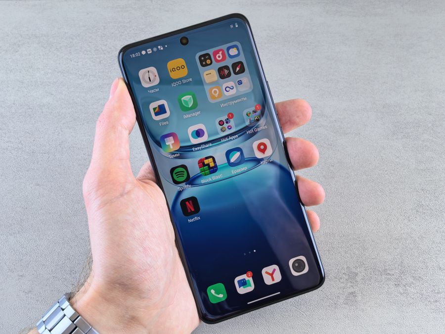 man holding smartphone with app icons displayed