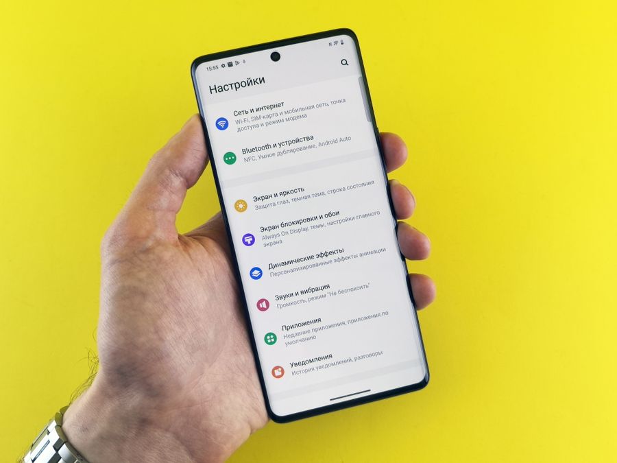 hand holding smartphone with settings menu displayed — Harbor views with full bars: coverage where travelers actually go.