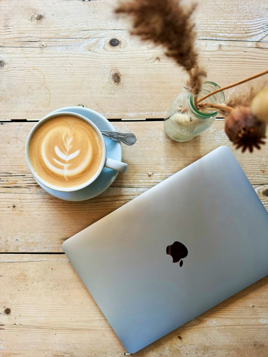 cozy cafe workspace with laptop and latte art — La escala en Panama: trabajar, streaming y mensajes, todo cubierto.