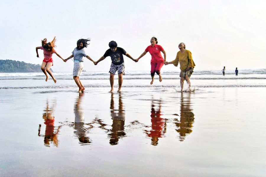 friends jumping at pangandaran beach — Support: Tardes de museo con audioguías en streaming, sin buffering.