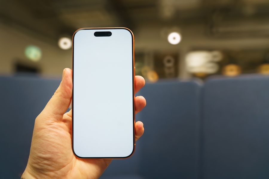 blank smartphone screen held in hand indoors — La oficina del asiento de ventana: correos enviados sobre el océano.