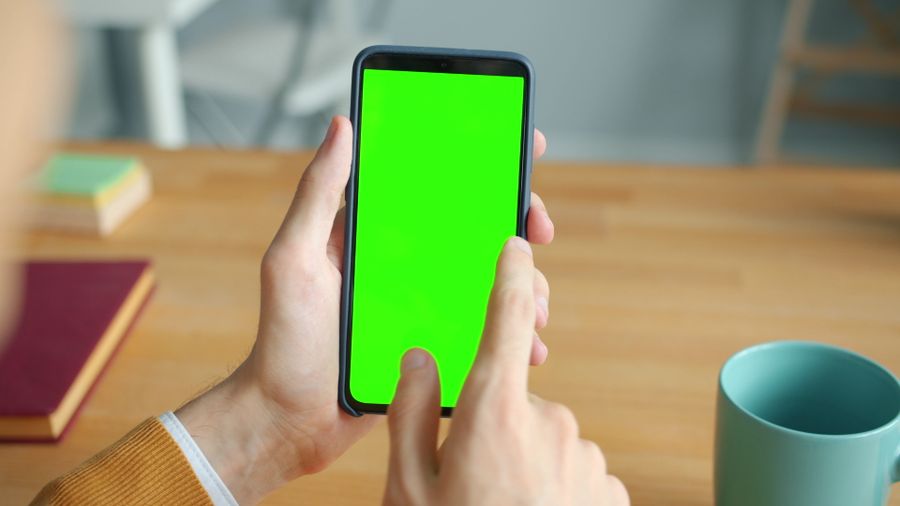 person using smartphone with green screen at desk — Mercados de COUNTRY: regatea con el conversor abierto, paga con un toque.