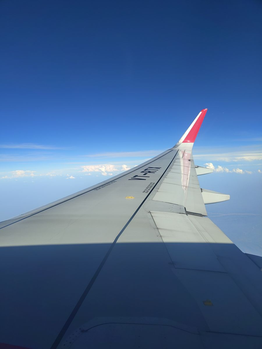 airplane wing view against clear blue sky — El skyline de Equatorial Guinea al atardecer: videollamada a casa con toda la ciudad detrás.