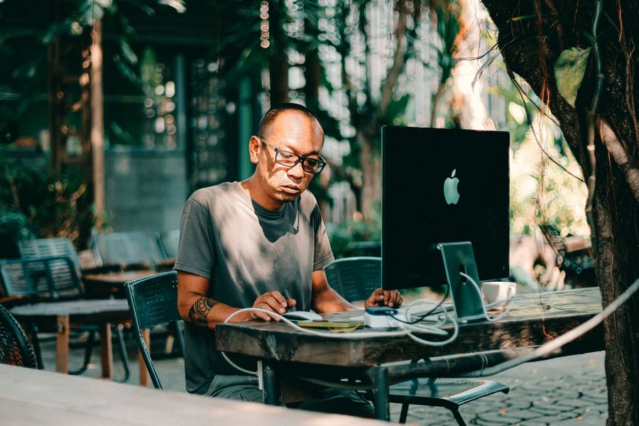 man working on computer at outdoor cafe — Data Usage Estimator: the fastest way to turn a vague travel question into a next step.