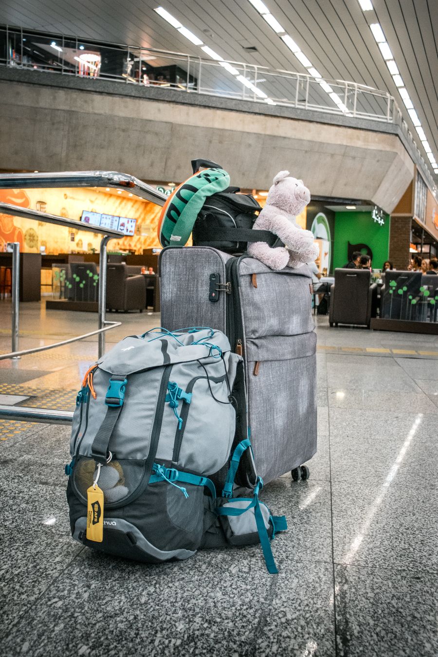 teddy bear sitting atop luggage left in airport — El hall de llegadas de Guatemala: en línea antes de la cinta de equipaje, siempre.