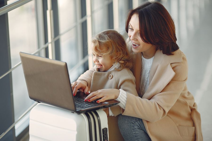 delighted mother with daughter typing on laptop in airport — El agente dimensiona planes, verifica compatibilidad y resuelve instalaciones.