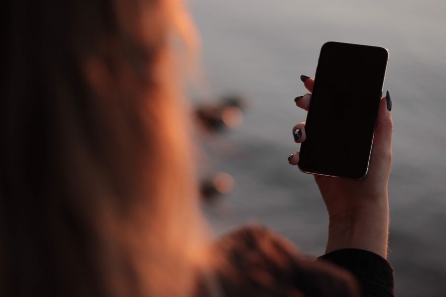woman holding iphone in hand — Tardes de museo en Bolivia: audioguías en streaming, sin buffering.