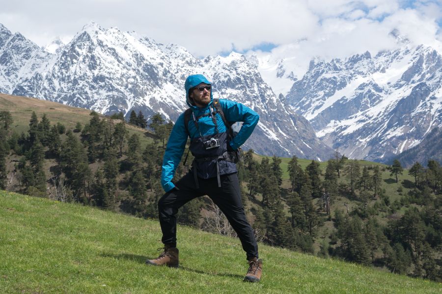 man standing on a grass with snow covered mountains background — Hora dorada en Colombia, totalmente en línea — el viaje se documenta solo.