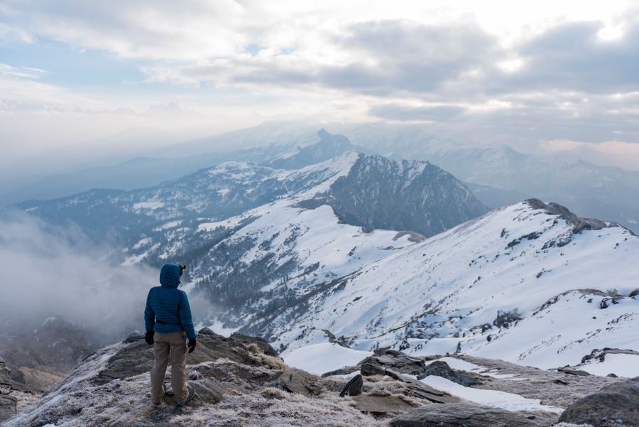 a man looking at mountains — Docs: Las caminatas al amanecer empiezan con el clima — datos activados, botas puestas.