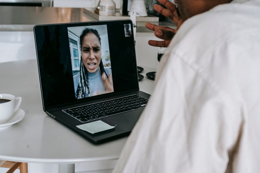 unrecognizable ethnic man having video conference with upset girlfriend — Azoteas de Costa Rica: videollamadas a casa con el skyline detrás.