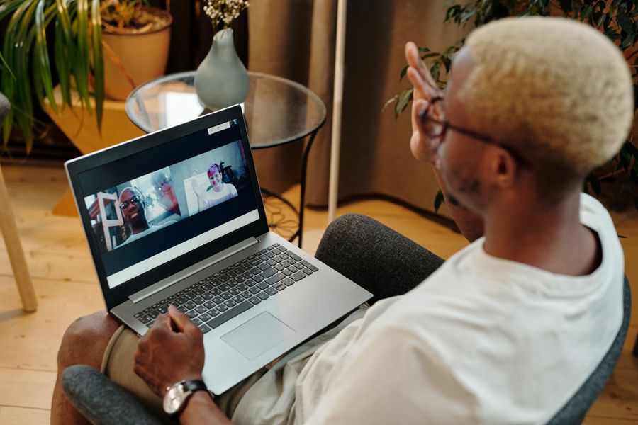 man video calling using a laptop while sitting on a chair — Latency to Destination: one question, answered well, instead of ten open tabs.