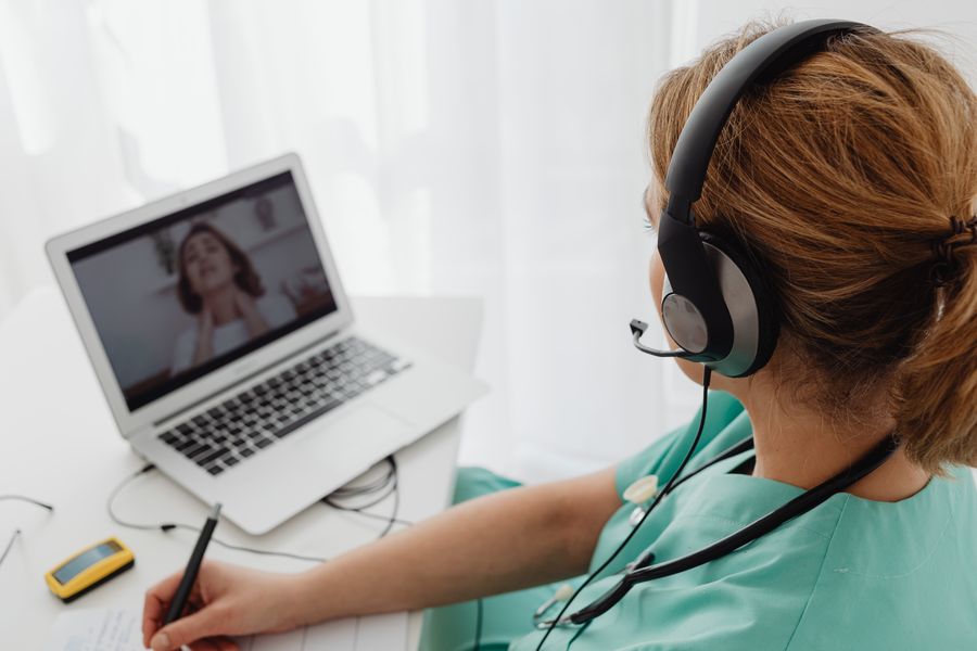 woman wearing headphones while video calling to patient — Día de mercado en Nicaragua: búscalo, tradúcelo, paga con el teléfono.