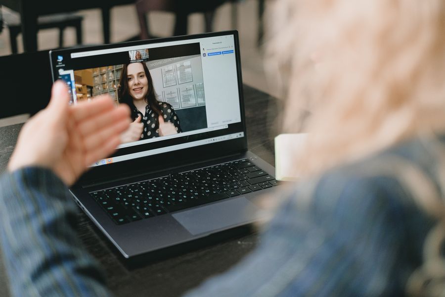 female coworkers having video conference via netbook and discussing project — Amanecer sobre Venezuela: clima revisado, botas puestas, datos activados.