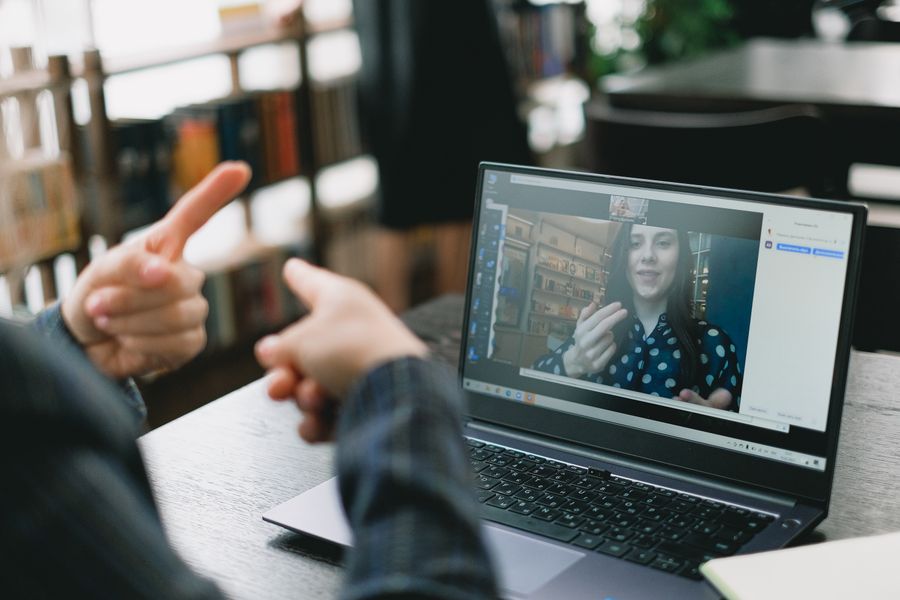 young lady learning sign language during online lesson with female tutor — Puestos callejeros y pago móvil: cena pedida sin una palabra del idioma.