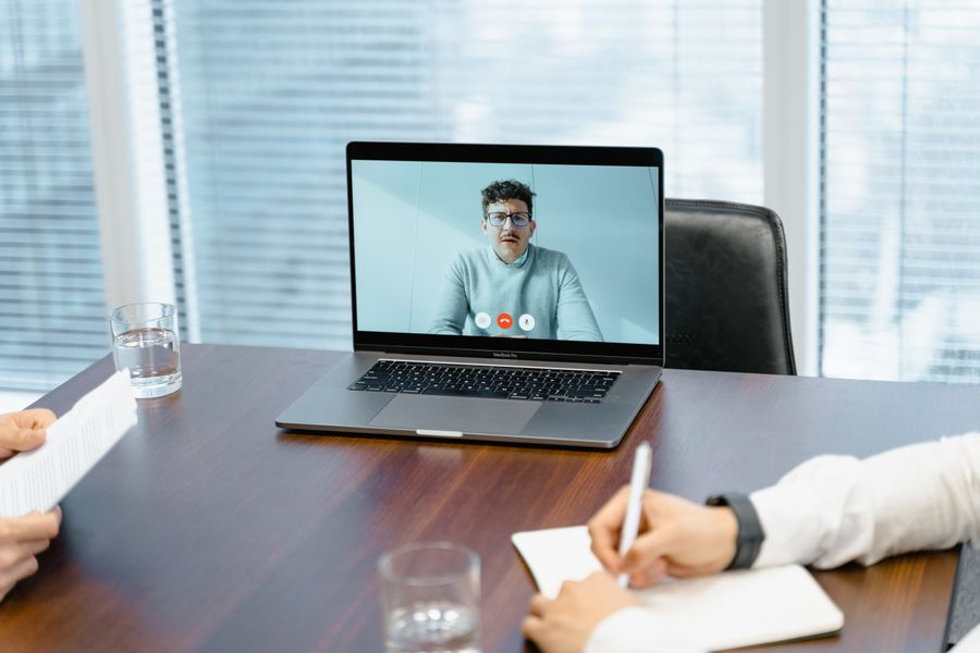 a businessman in an online meeting — El skyline de Bolivia al atardecer: videollamada a casa con toda la ciudad detrás.