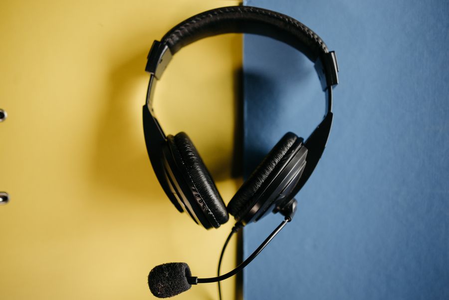 black corded headphones on blue and yellow surface — La cola de SIM de Peru, saltada por completo: instalada antes de que abrieran las puertas del avión.