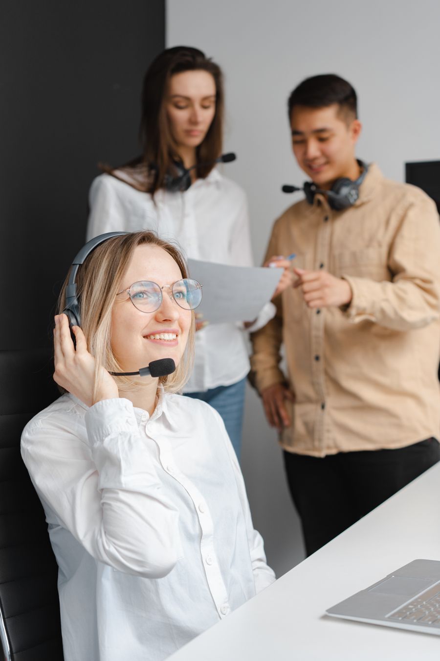 woman in a white shirt smiling while holding her headset — El mercado nocturno de COUNTRY: puestos mapeados, platos imprescindibles traducidos.