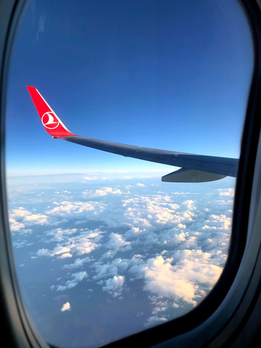 a turkish airplane flying above the white clouds — Pregunta por cualquiera de 195 destinos — el agente conoce la red detrás de cada uno.