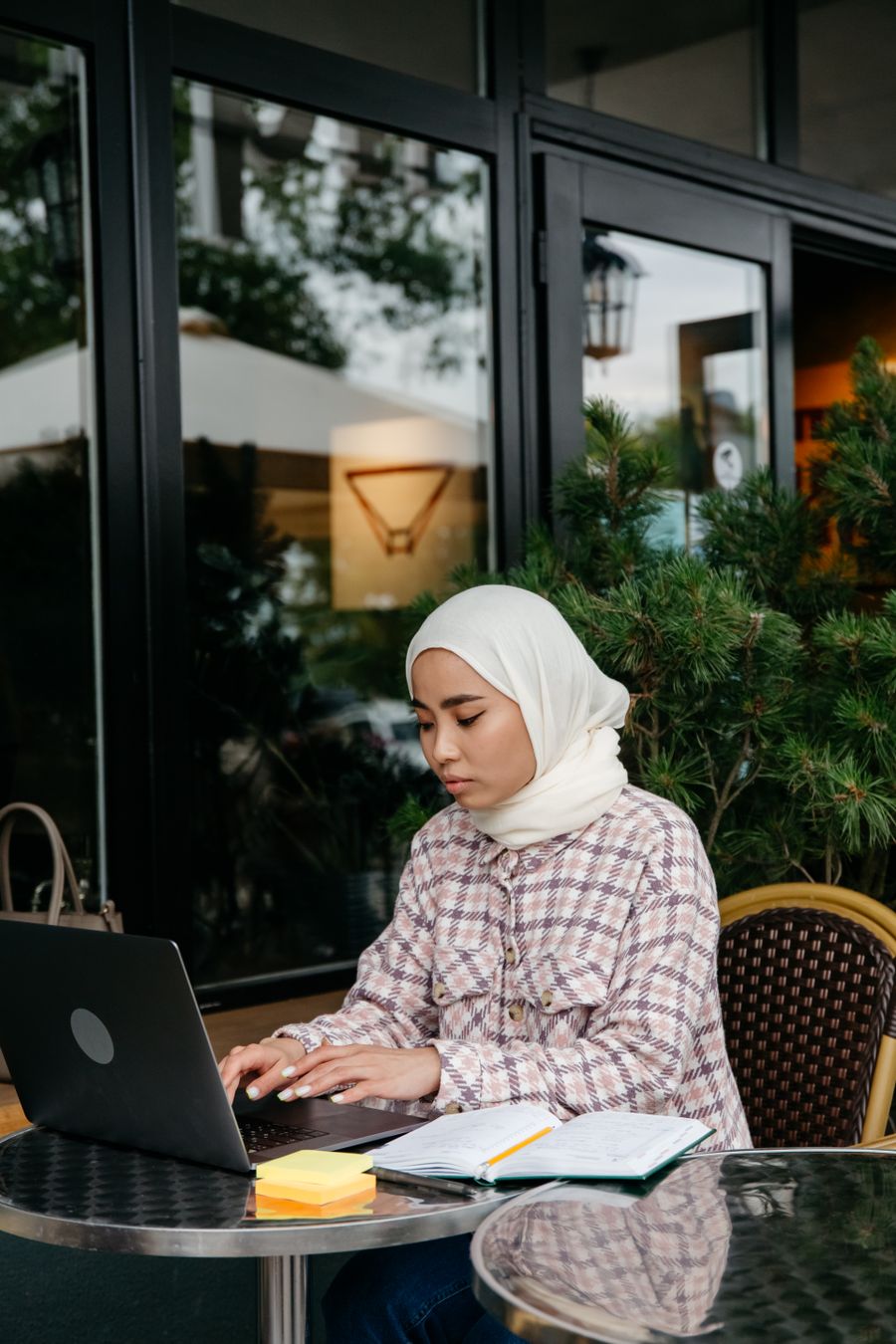 a woman in white hijab using a laptop