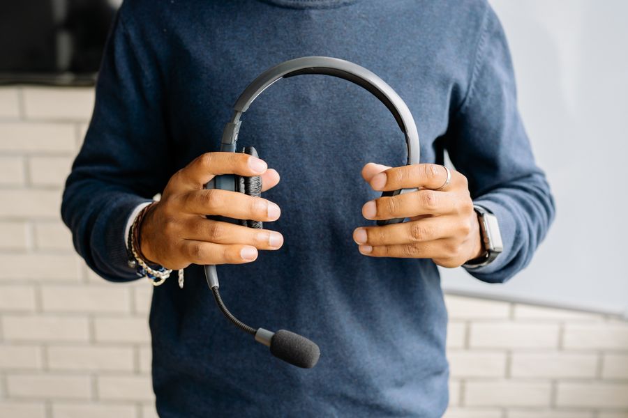 a person holding a headset — Rainy-day backup plan: indoor attractions researched from the hostel bunk.