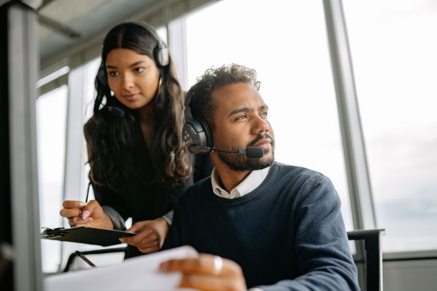 man and woman wearing headphones while working in the office — El trayecto en Equatorial Guinea: podcasts, mensajes y mapas, sin zonas muertas.