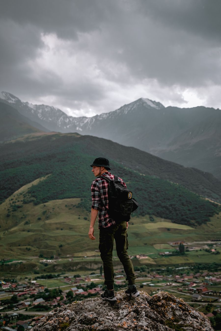 male hiker standing on the rock overlooking the green mountains — El Tele Agent adjunta el formato de número correcto para tu destino.